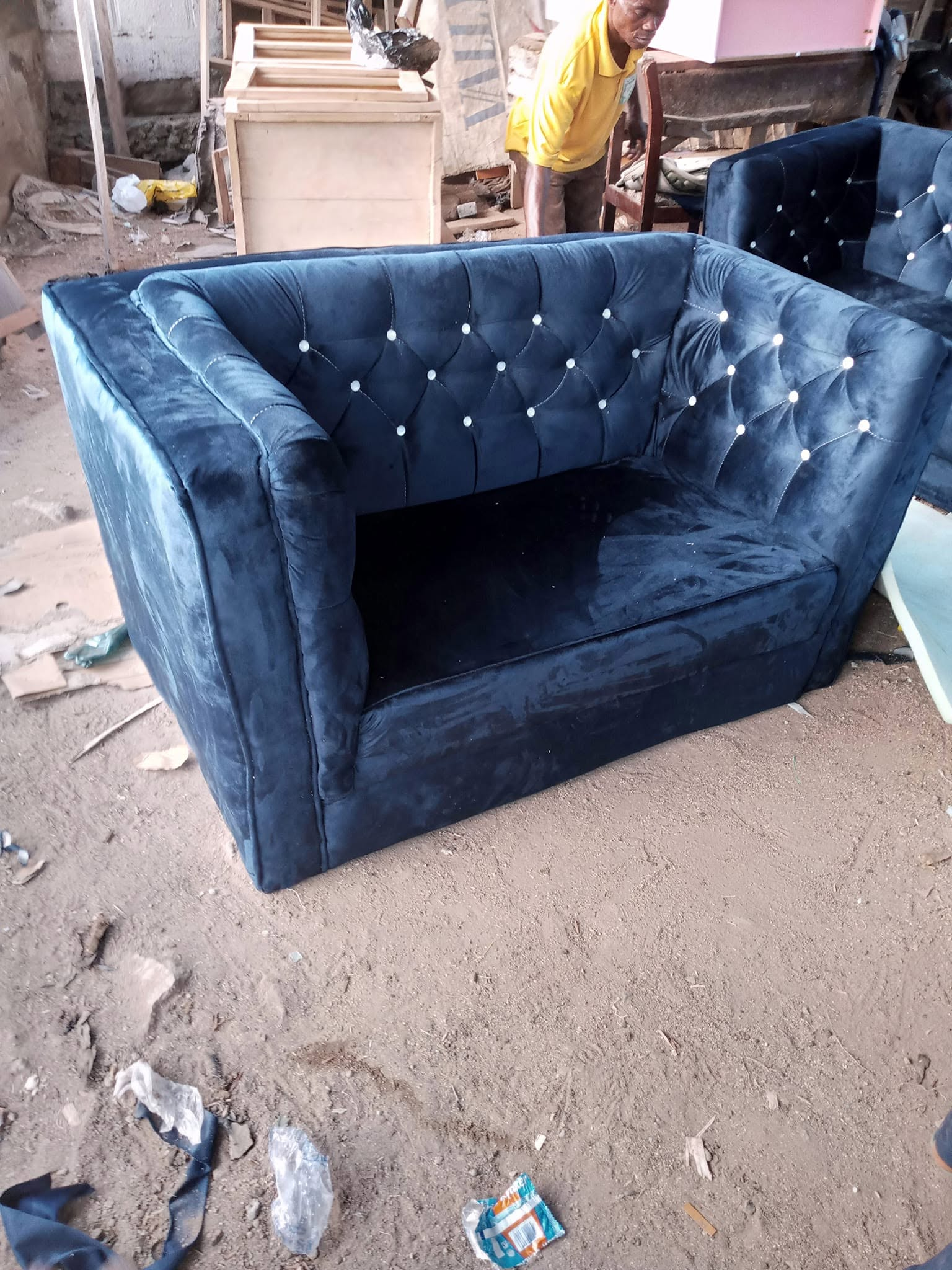 Navy tufted armchair photographed at the workshop