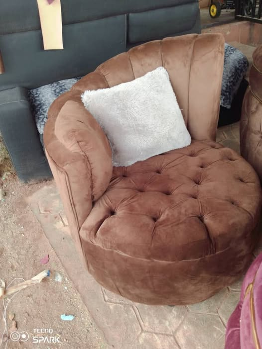 Brown round tufted accent chair with a light cushion photographed at the workshop