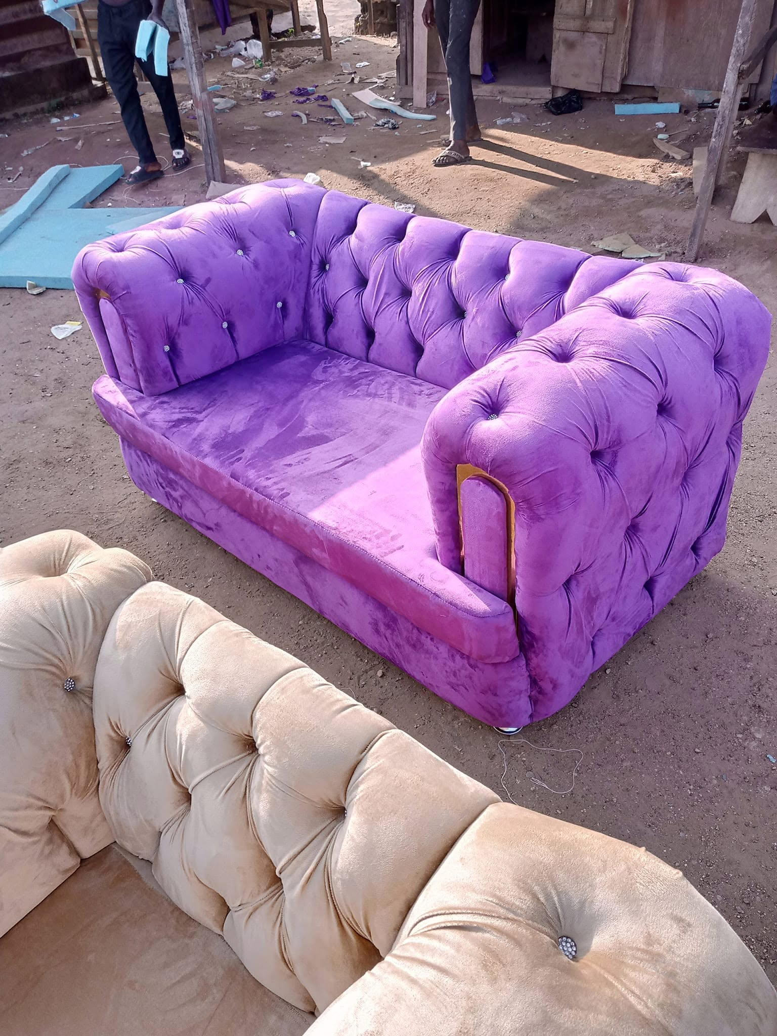 Purple tufted loveseat with gold arm detail photographed in the workshop area